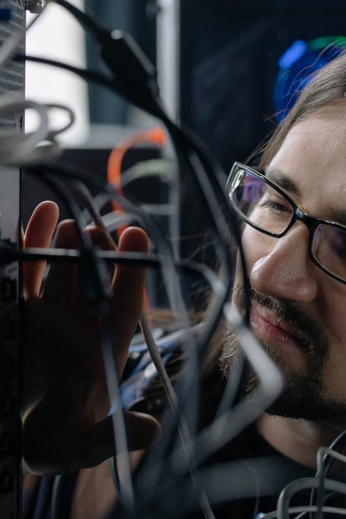 Professional IT specialist handling network cables in a server room.